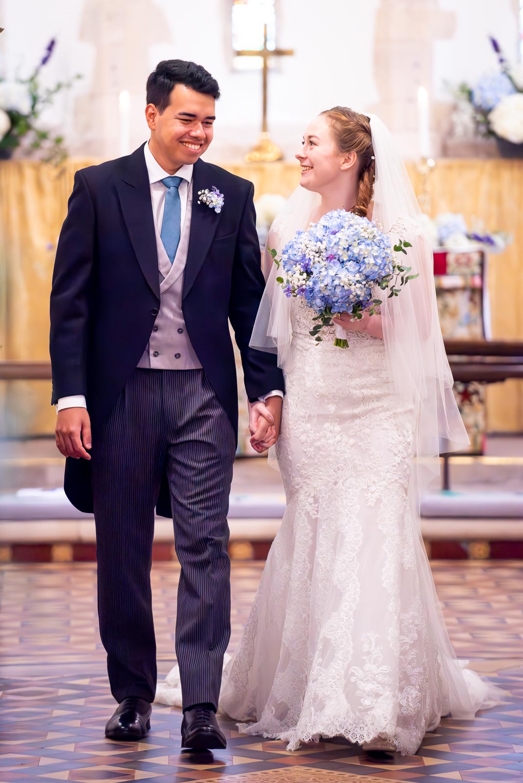 Callum and Lily walk down the aisle after getting married at St Nicholas Church in Iford.