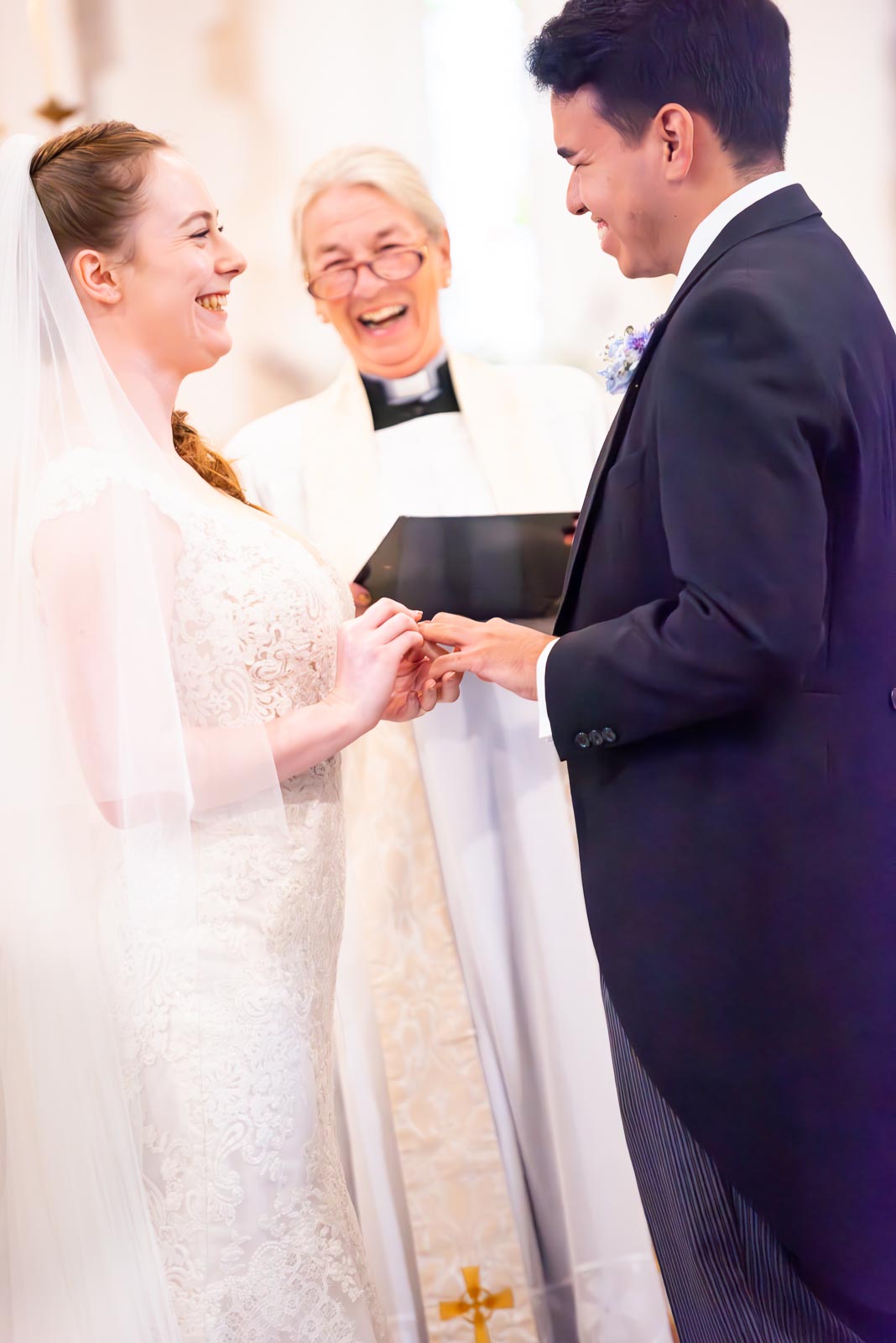 Callum and Lily laugh whilst saying their vows at St Nicholas Church in Iford.