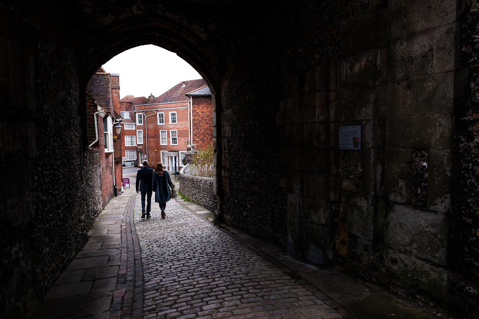 Melanie and Ryan walk through the archway at Lews Castle after their wedding at Lewes Register Office.