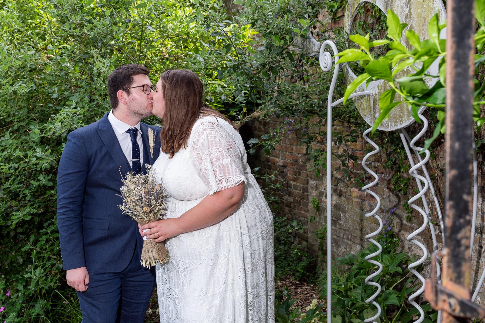 Sophie and Nathan embrace in the secret garden in Southover Grange after their wedding in Lewes Register Office.
