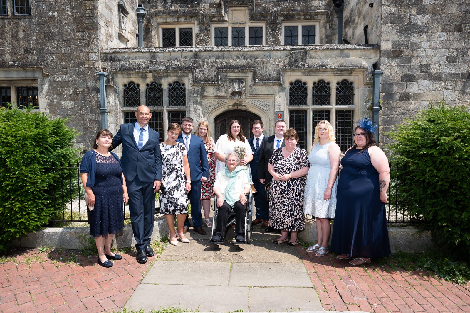 Sophie, Nathan and their guests pose on front of Lewes Register Office after their wedding.