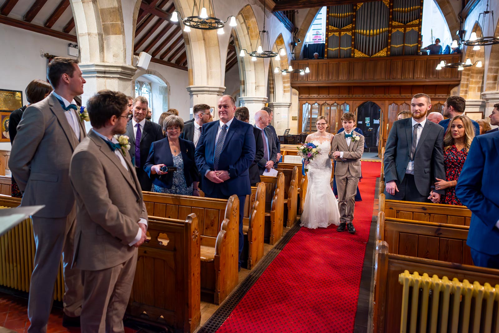 Stephanie is accompanied by her brother down the aisle at The Church of St Peter and St Paul in Hellingly before her wedding to Lewis.