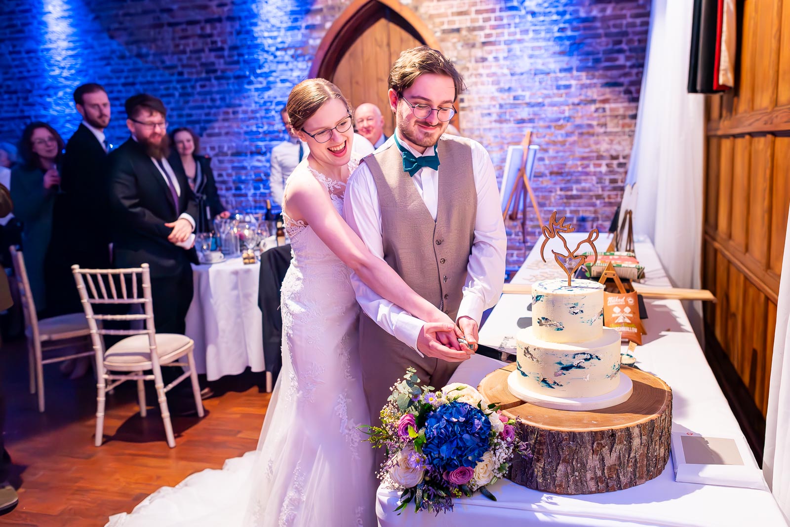 Lewis and Stephanie cut the wedding cake in the Flint Halls at Folkington Manor near Polegate.