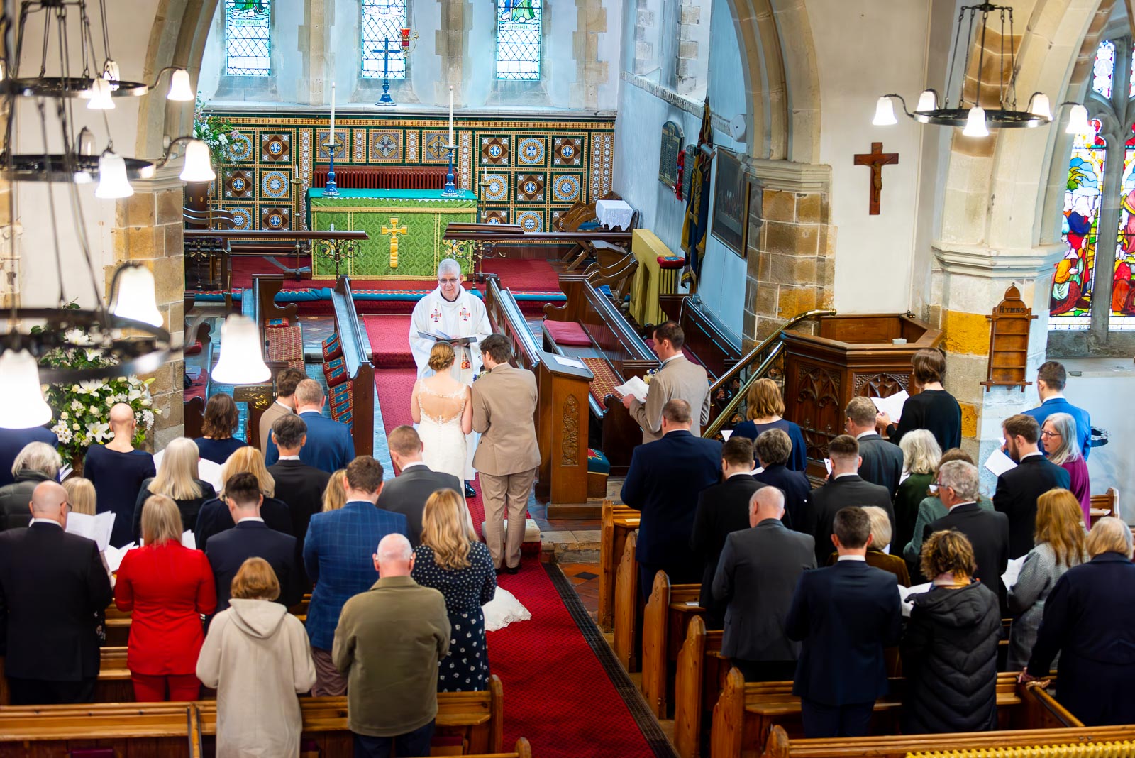 An elevated view of Stephanie and Lewis reading their vows at their Wedding at The Church of St Peter and St Paul in Hellingly. 