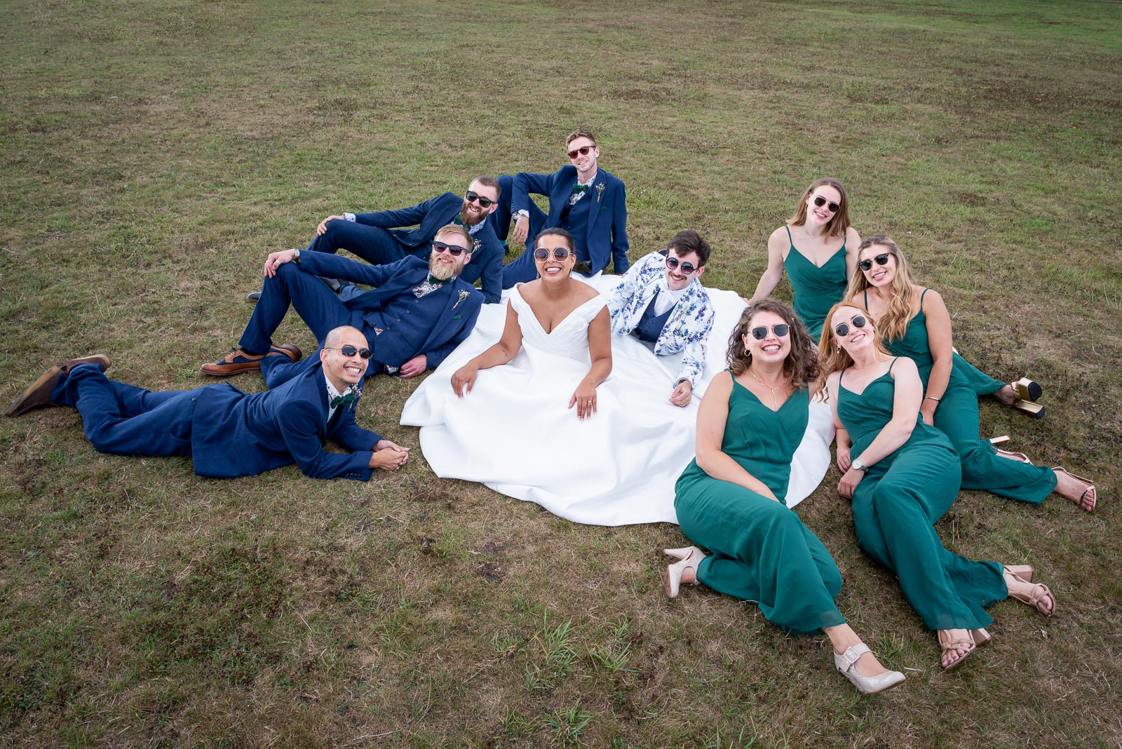 Groomsman and Bridesmaids surround Edward and Olivia in a seated pose at their Wedding Reception in Beechwood Hall & Rural Park.