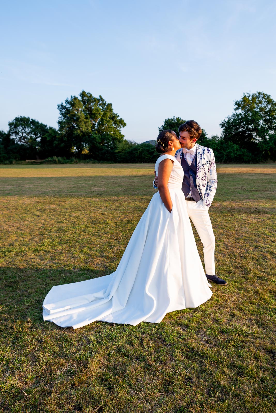 Edward and Olivia embrace in some low, warm sunlight at their Wedding Reception in Beechwood Hall & Rural Park.