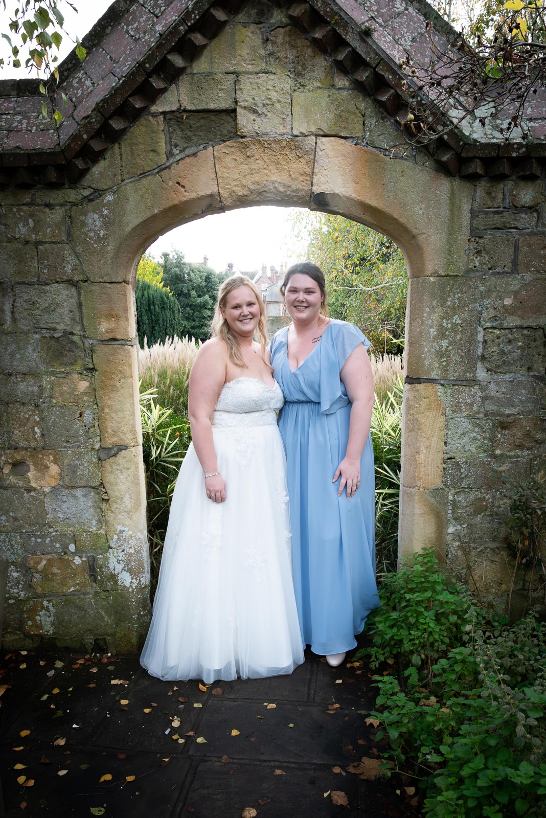 Eliana and her sister pose in one of the picturesque arches at Southover Grange after marrying Jacob.