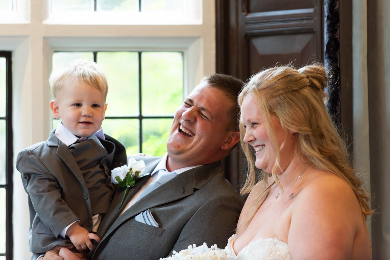 Eliana, Jacob and their two year old son enjoy a funny moment in the Ainsworth Room at Lewes Register Office at their Wedding.