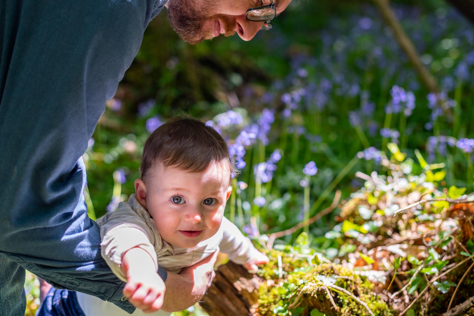 Neill holds his eight month old baby Alasdair among the bluebells at Battle Great Woods.