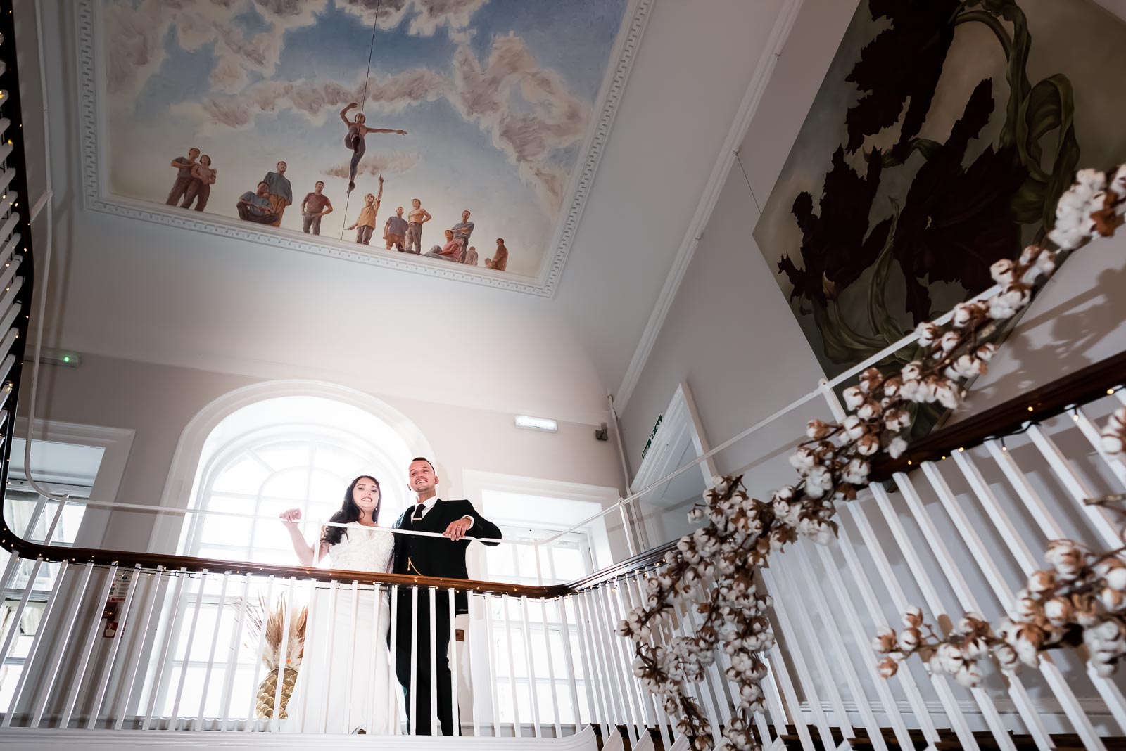 Natalie and Dean pose at the top of the stairs in Pelham House Hotel, Lewes after their wedding.