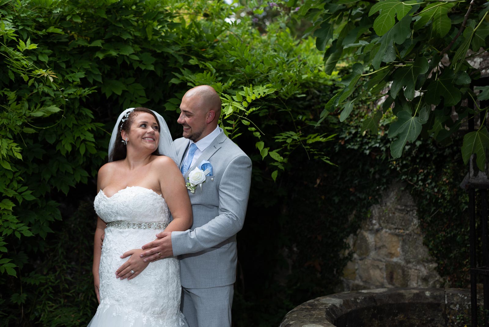 Billy and Soraya smile at eachother beside an ancient well at Southover Grange, Lewes. 