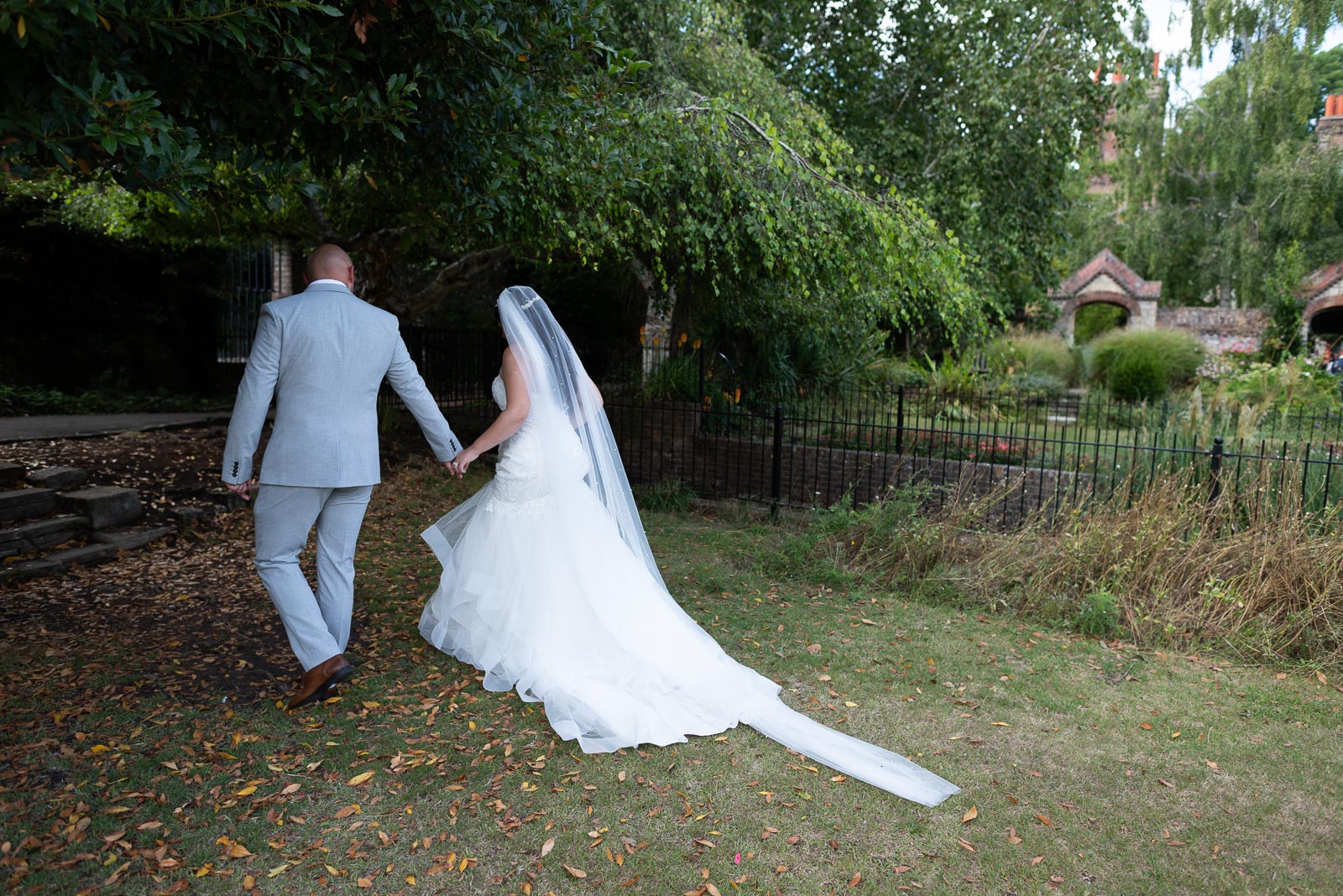 Billy and Soraya walk through the grounds at Southover Grange, Lewes after their wedding.