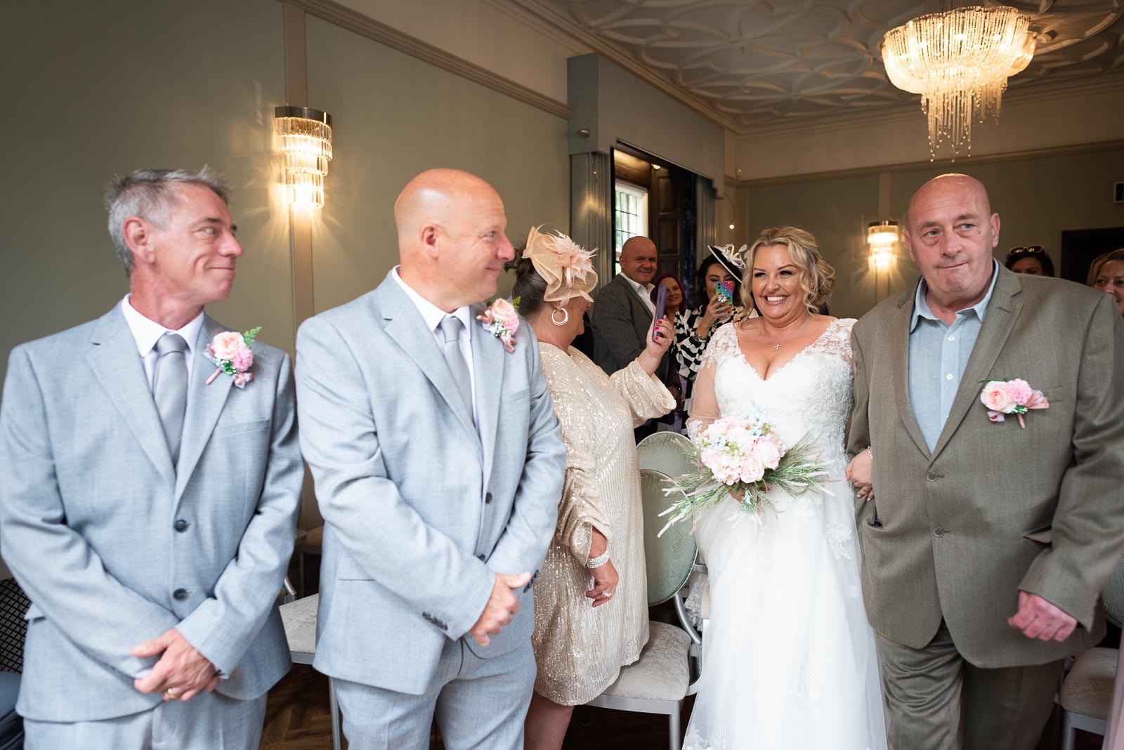 Matt looks at his bride to be Lou at the she arrives accompanied by her father top of the aisle in the Ainsworth Room at Lewes Register Office.