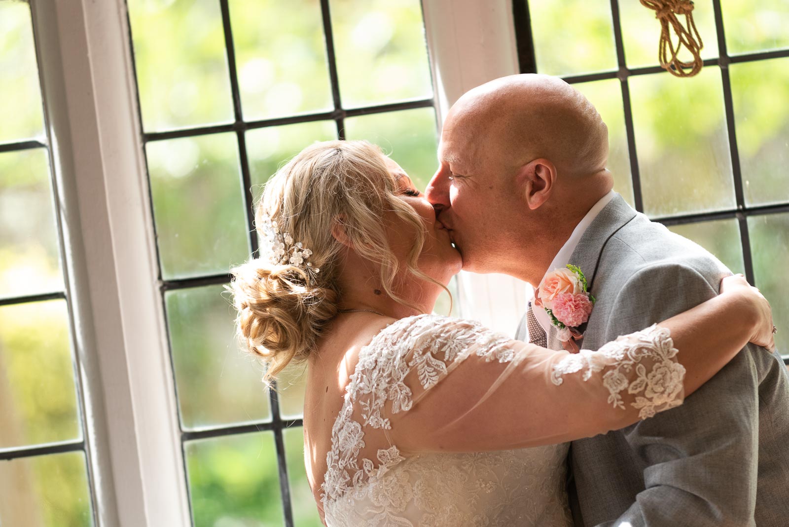Lou and Matt embrace after becoming husband and wife whilst standing at the top of the aisle in the Ainsworth Room at Lewes Register Office.