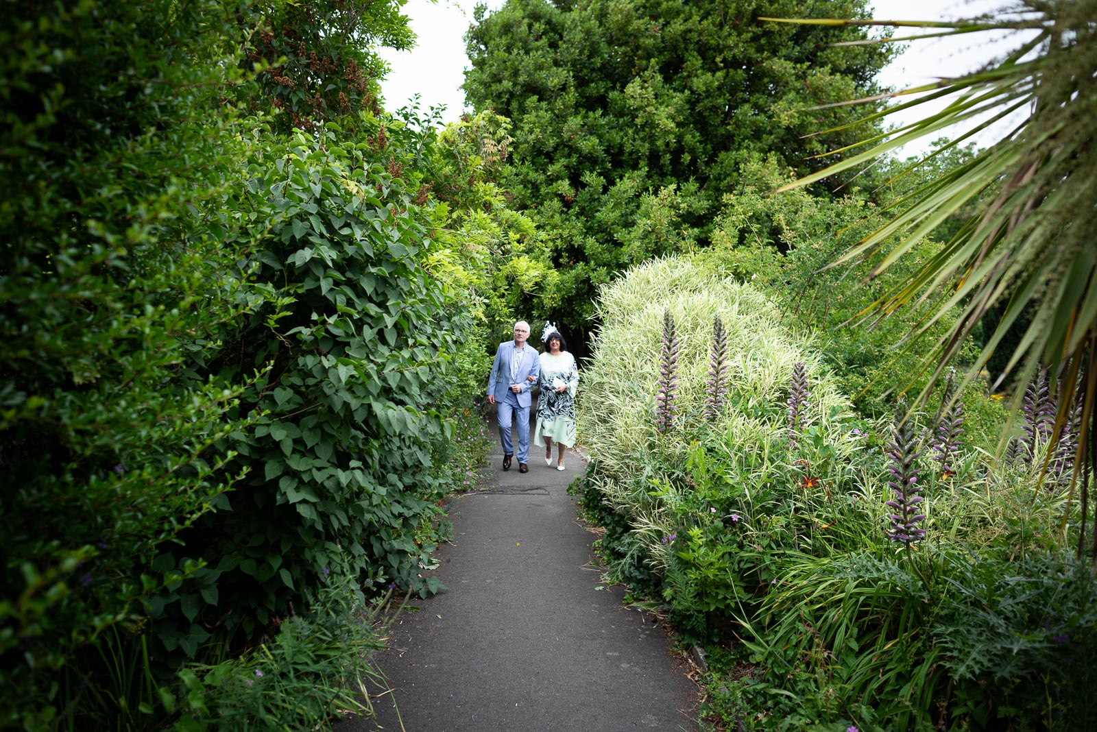 Ashifa and Julian walk through the thick greenary at Southover Grange in Lewes
