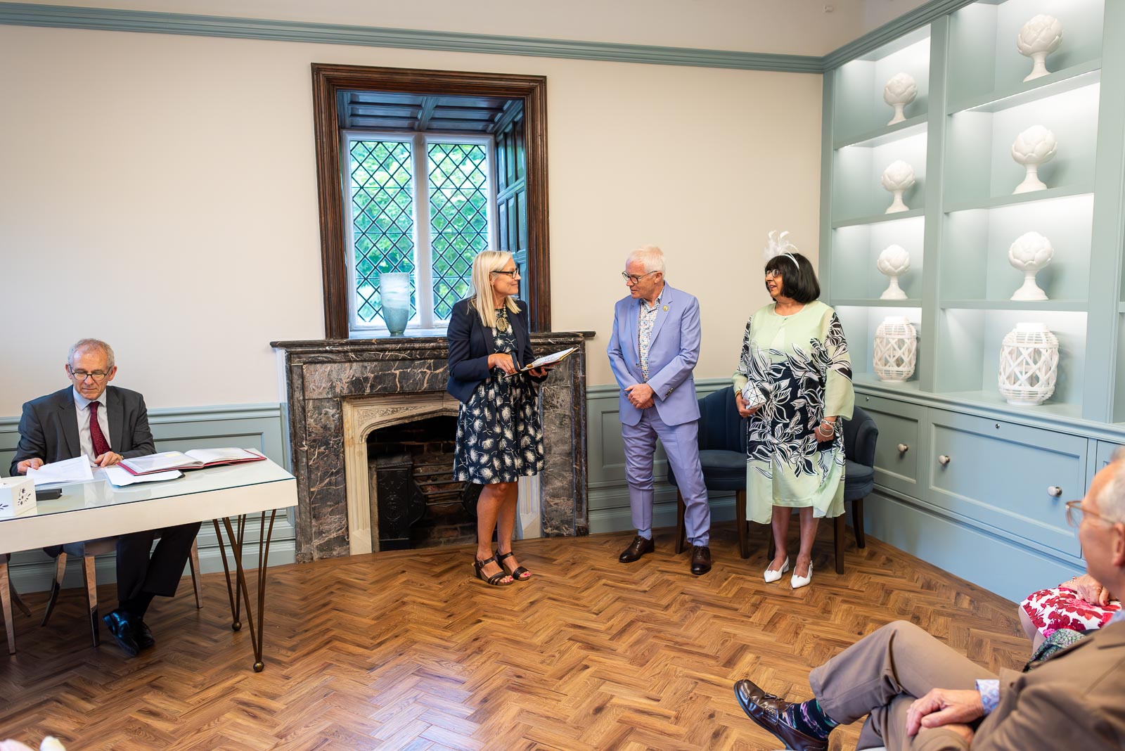 Ashifa and Julian sit at the bottom of the aisle surrounded by guests at Lewes Register Office