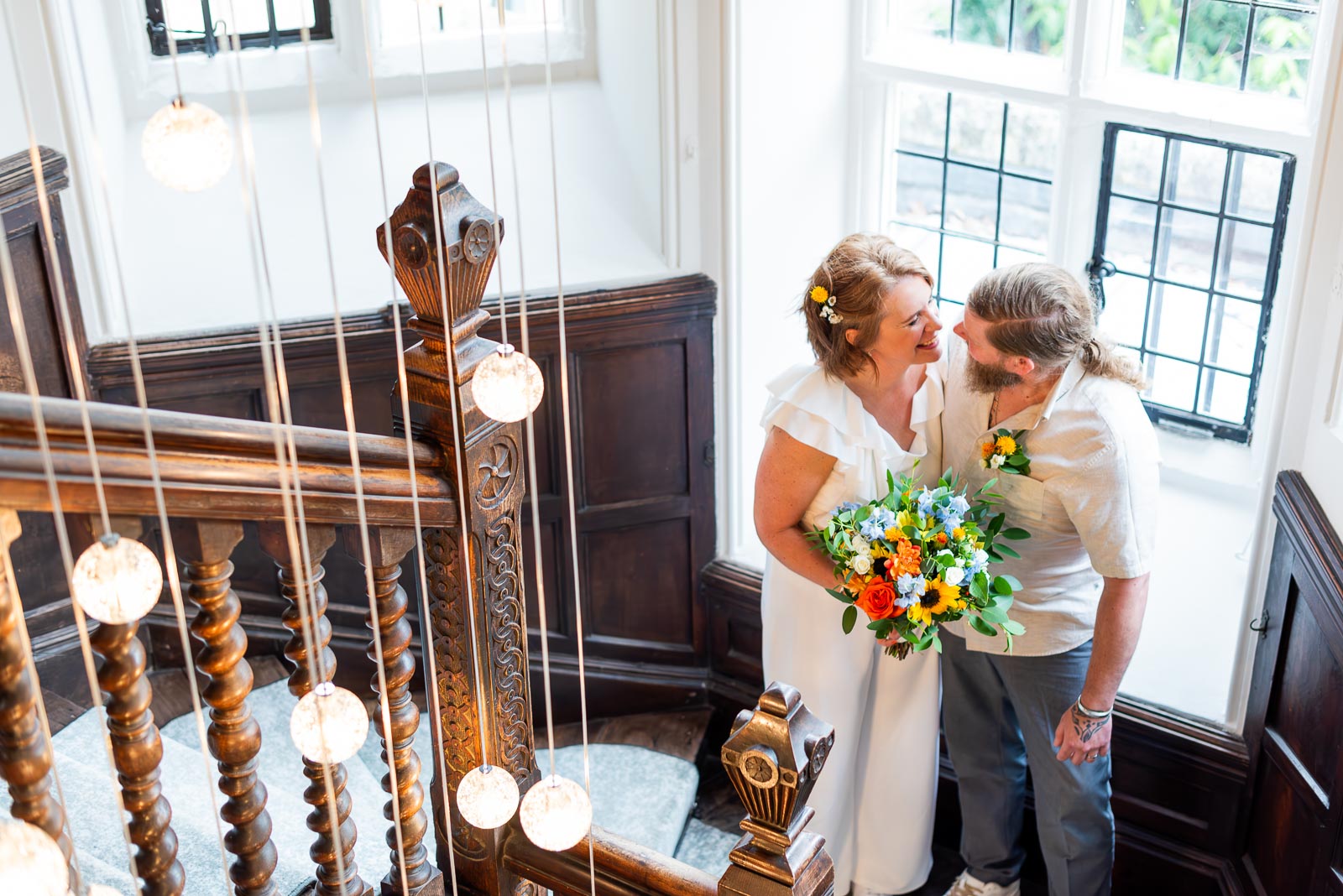 Mary and Mark look into eachothers eyes on the stairs at Lewes Register Office