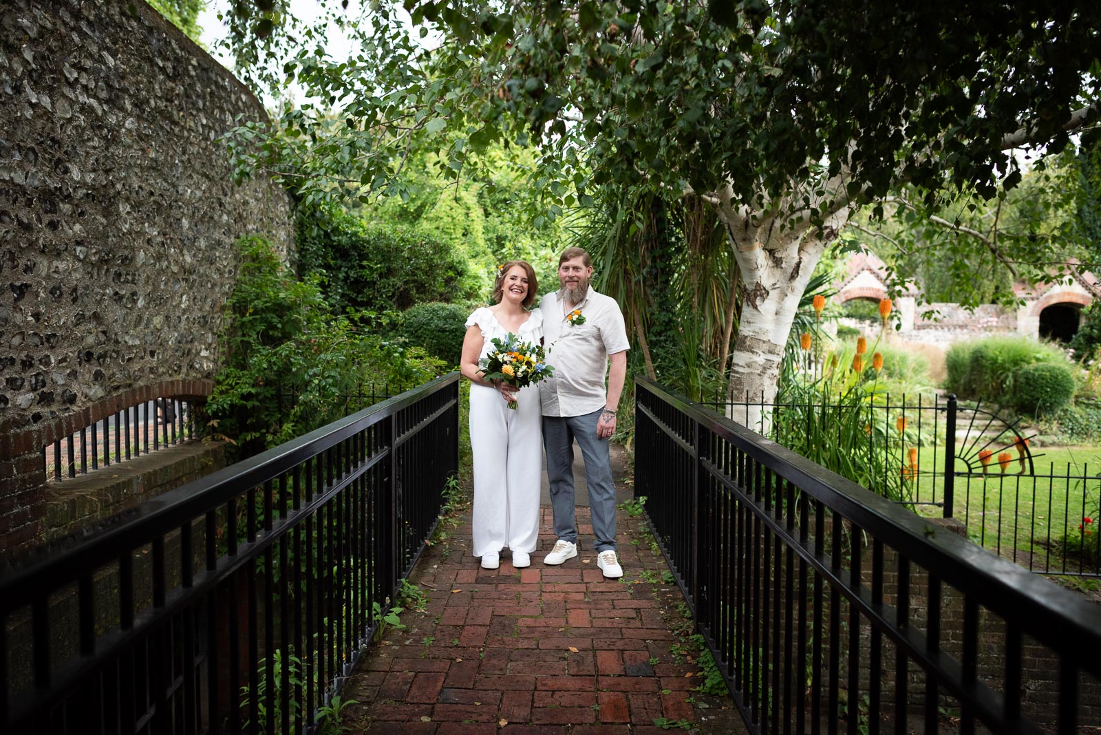 Mary and Mark cross a bridge over the stream in Southover Grange, Lewes