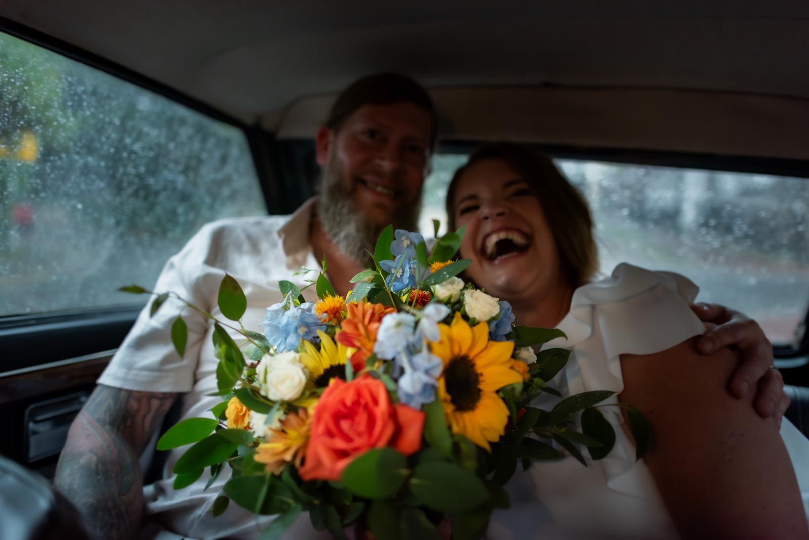 Mary and Mark keeping dry in their car outside Lewes Register Office after their wedding
