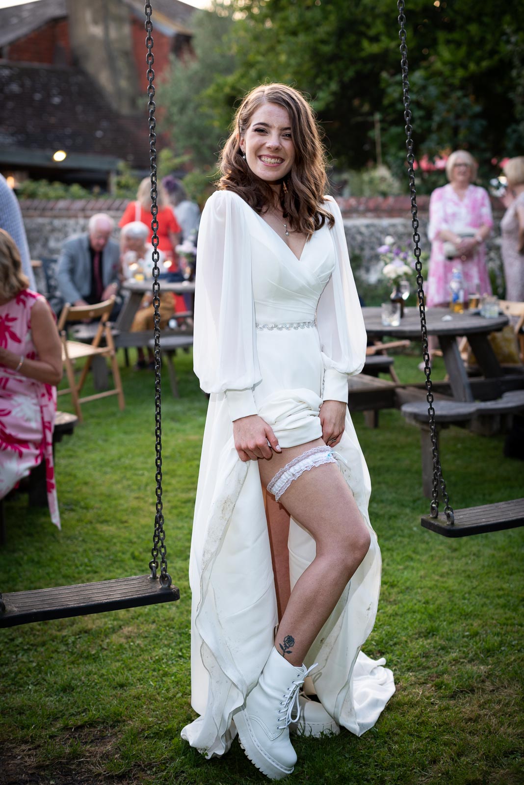 May shows her garter after marrying Mark at the Wedding Reception in the garden of the Anchor Inn in Ringmer