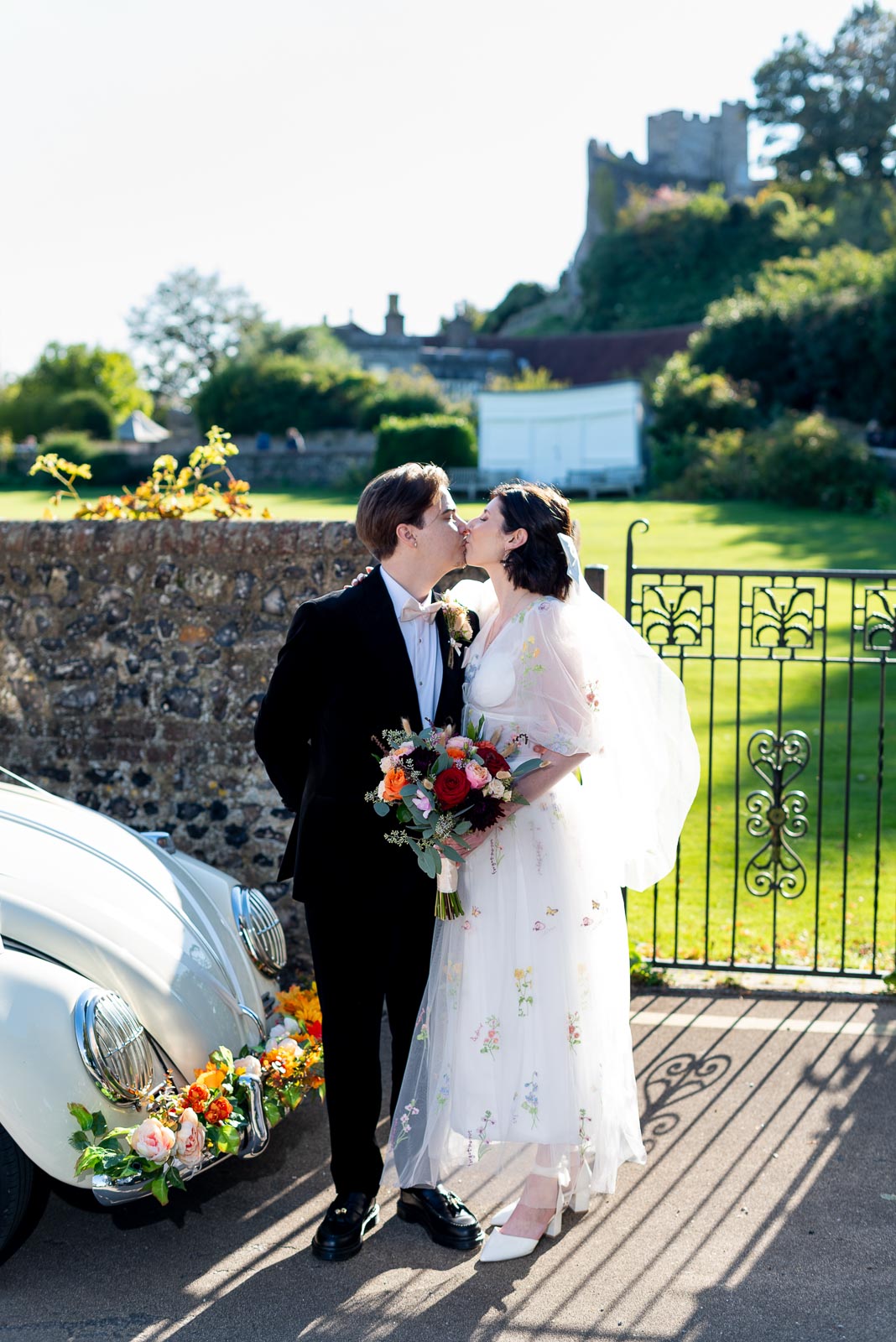 Lola and Laurance kiss next to the wedding car with Lews Castle in the backgraound after their wedding.