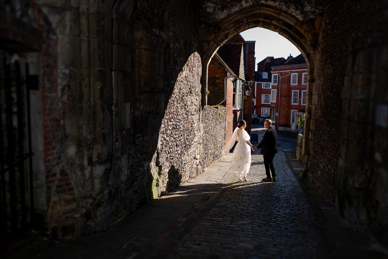 Lola and Laurance walk through the arch of Lewes Castle after their wedding.