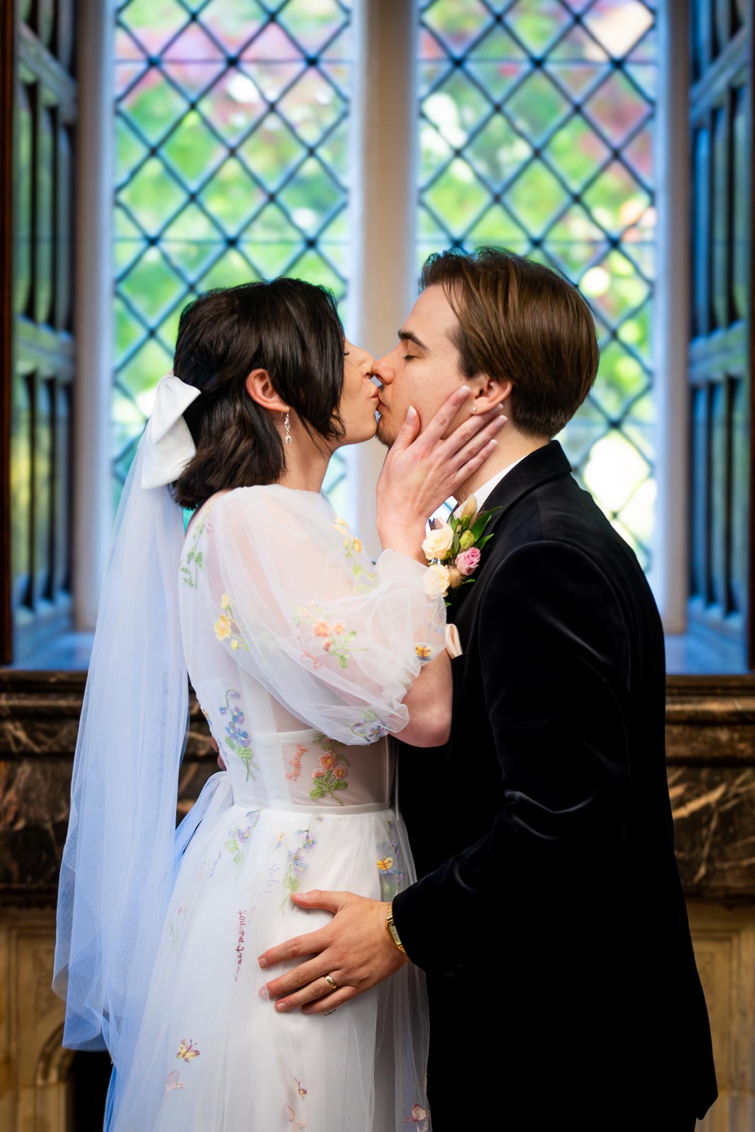 Lola and Laurance kiss at the top of the aisle in the Ainsworth Room at Lewes Registry Office after their wedding.