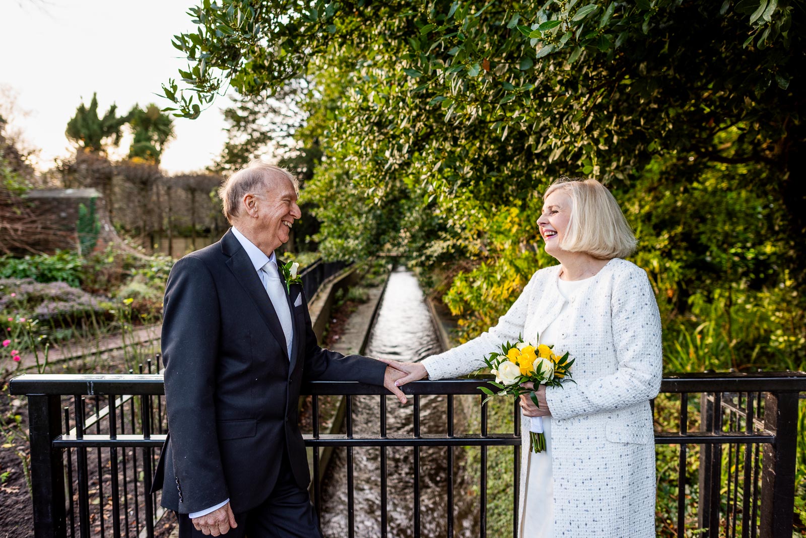 Peter and Dawn enjoy some late year sun on one of the bridges in Southover Grange crossing Winterbourne Stream after their wedding at Lewes Registry Office.