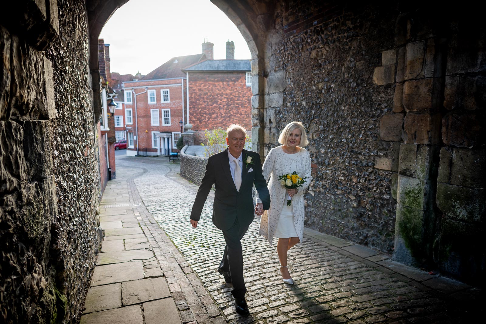 Peter and Dawn walk through the entrance of Lewes Castle after their wedding. 