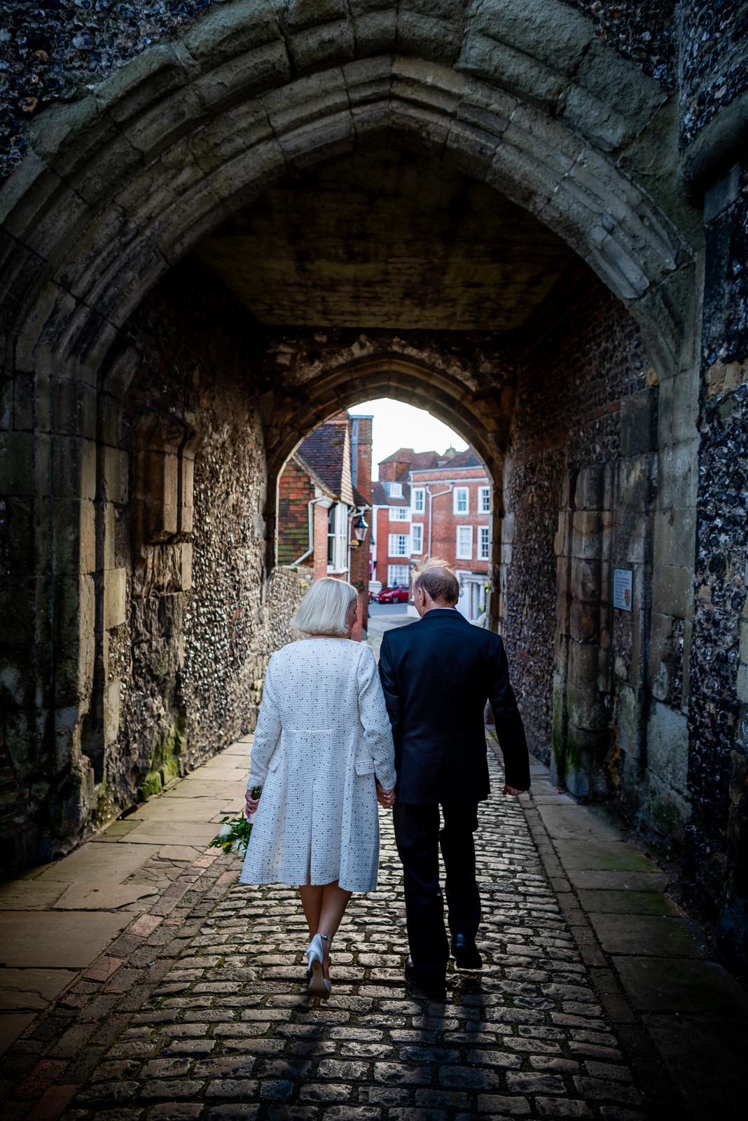 Peter and Dawn walk through the entrance of Lewes Castle after their wedding. 