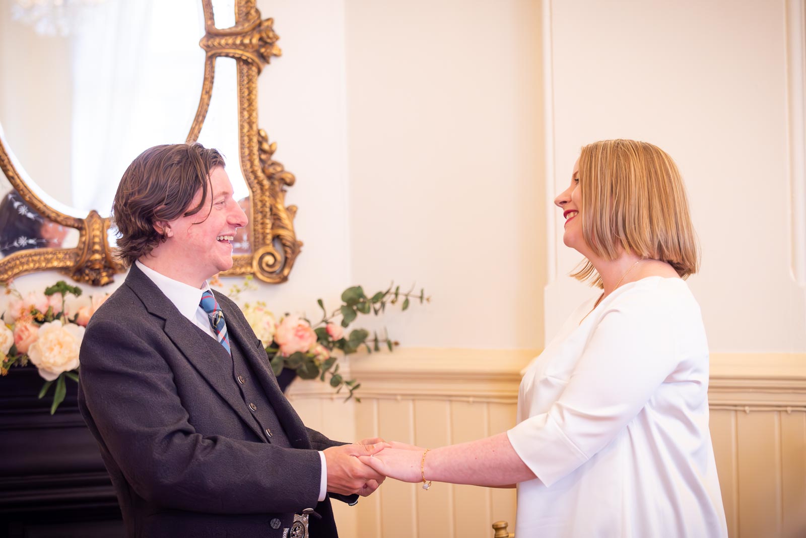 Clare and Sam laugh whilst saying their vows in the Regency Room at Brighton Town Hall.