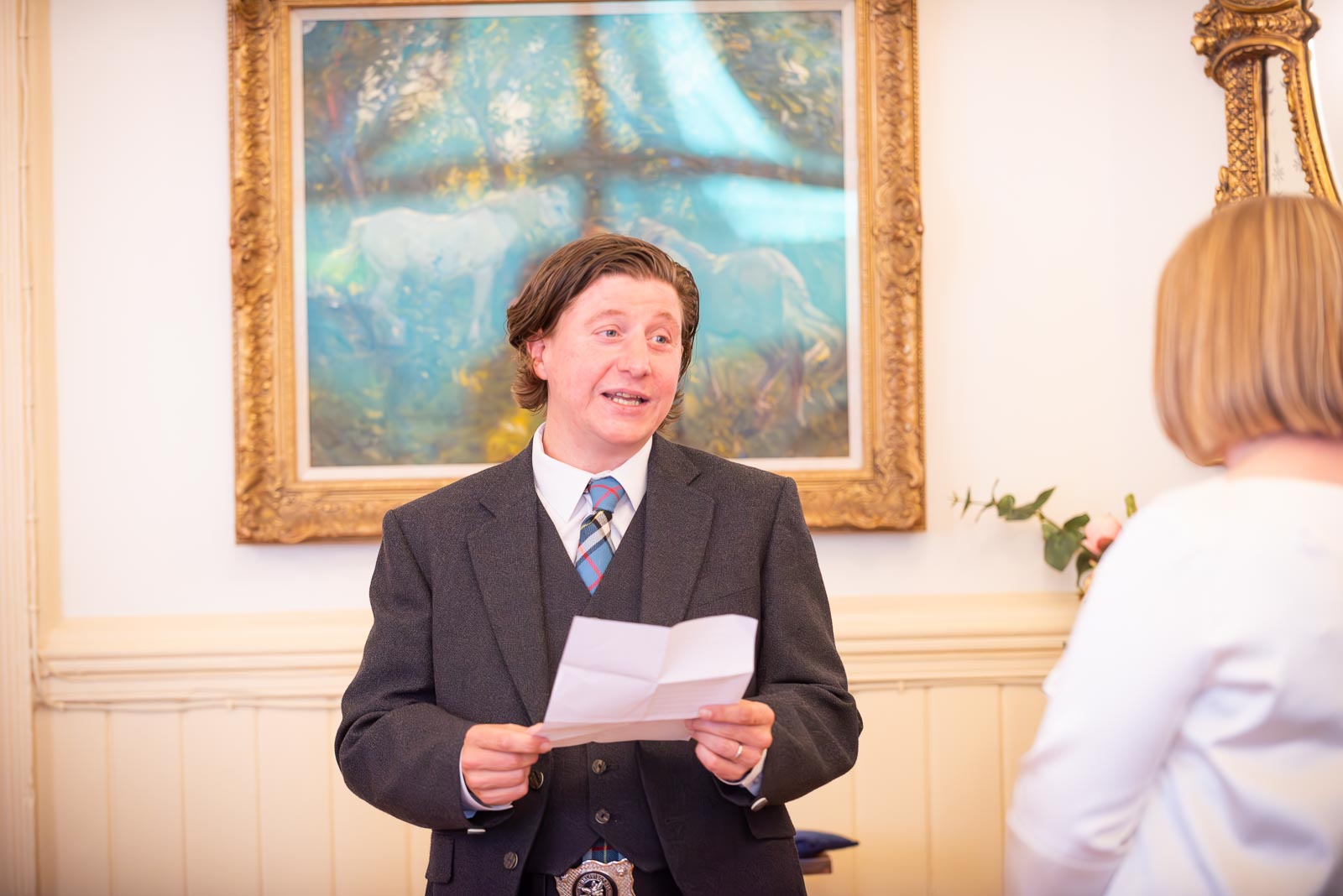 Sam reads a handwritten note to Clare during their Civil Partnership in the Regency Room at Brighton Town Hall. 
