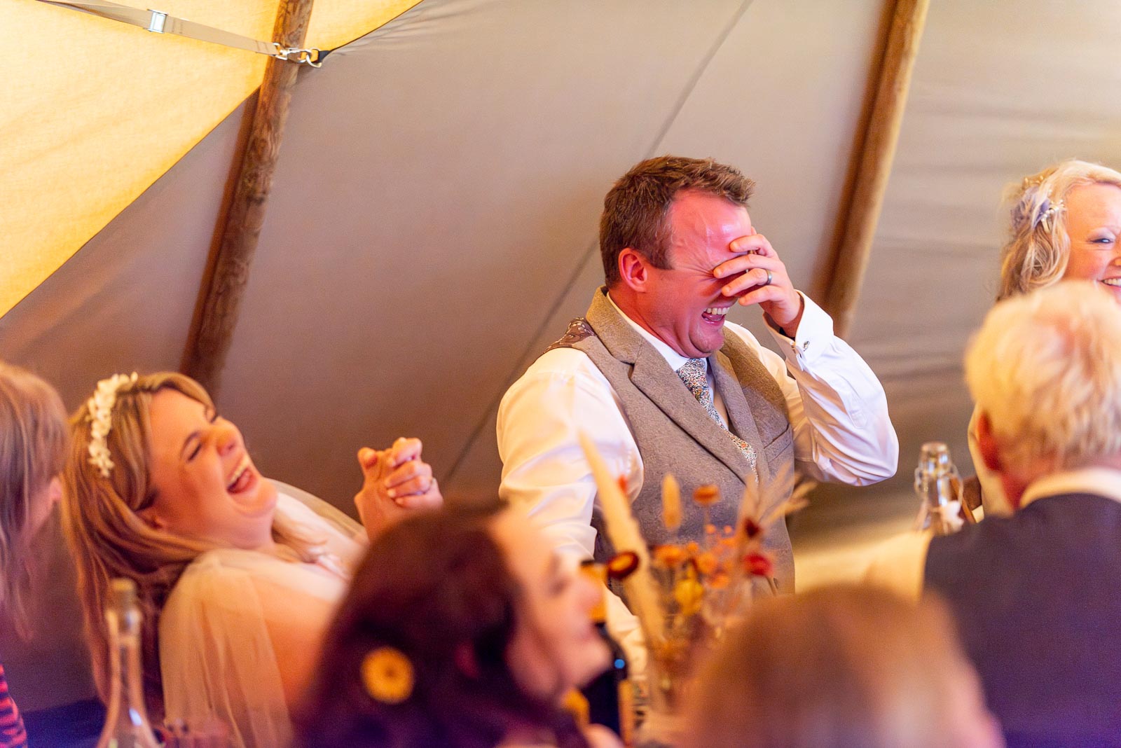 Eleanor and Marc laugh heartily during the best man speech at the Party Field near Lewes.