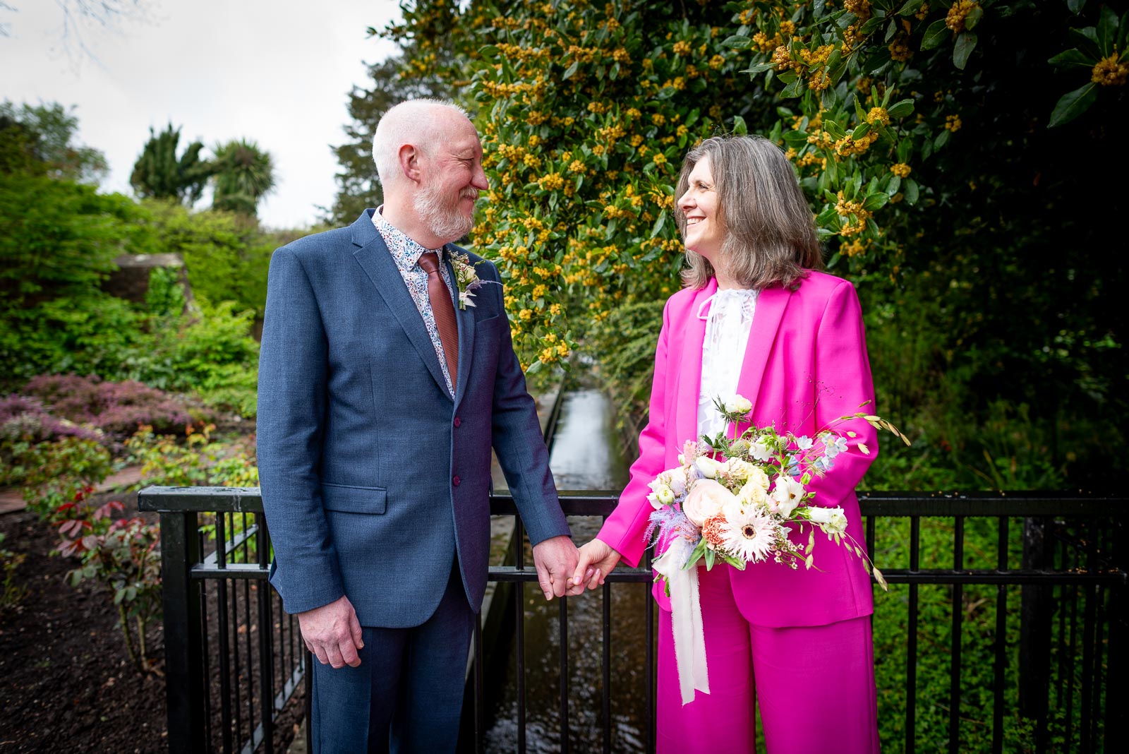 Helen and Tony stand over the Winterbourne Stream at Southover Grange in Lewes following their wedding