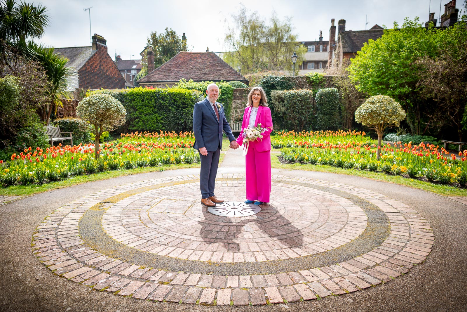 Helen and Tony are backlit in the secret garden at Southover Grange following their wedding