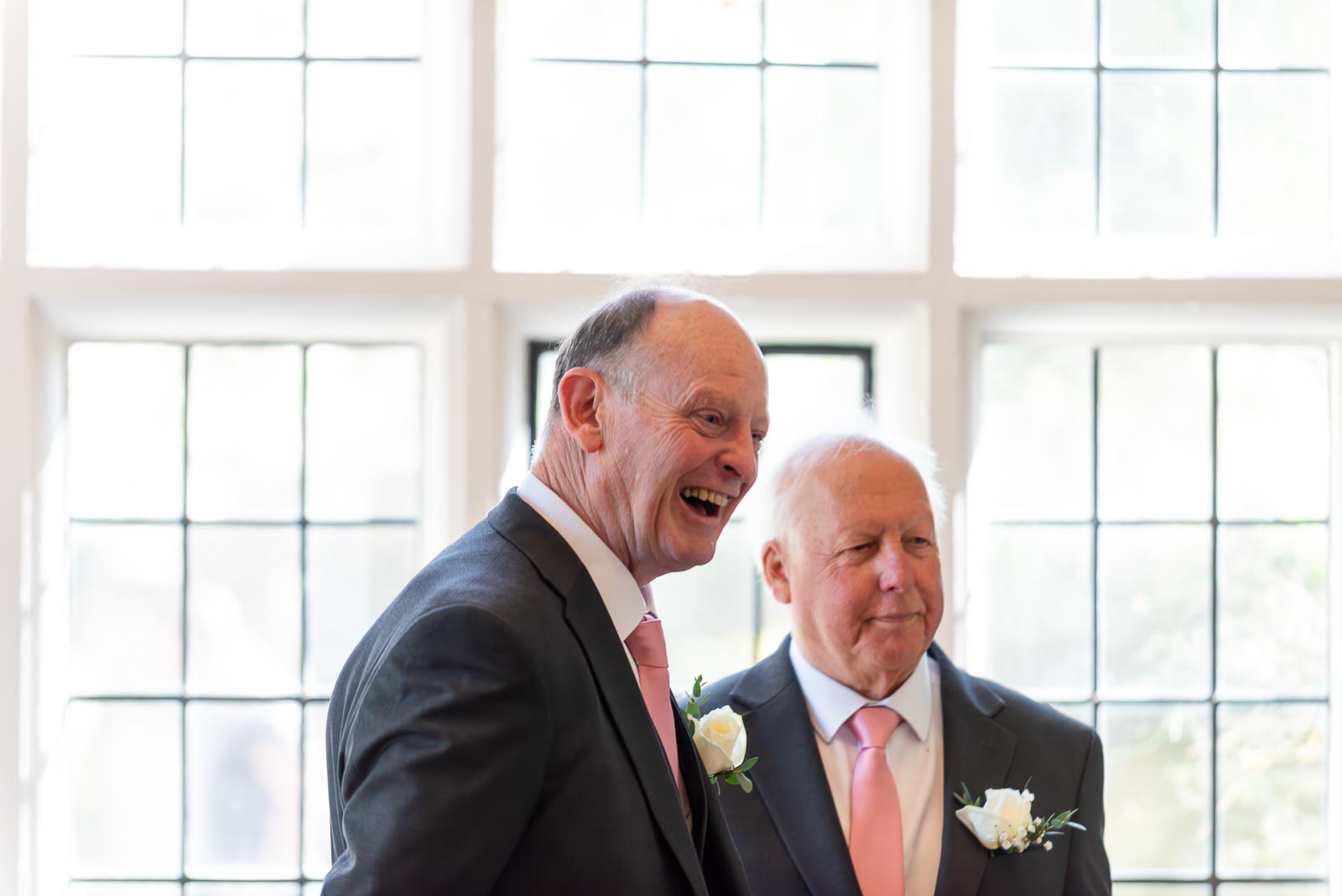 John and his best man wait happily at the top of the aisle in the Ainsworth Room at Lewes Registry Office