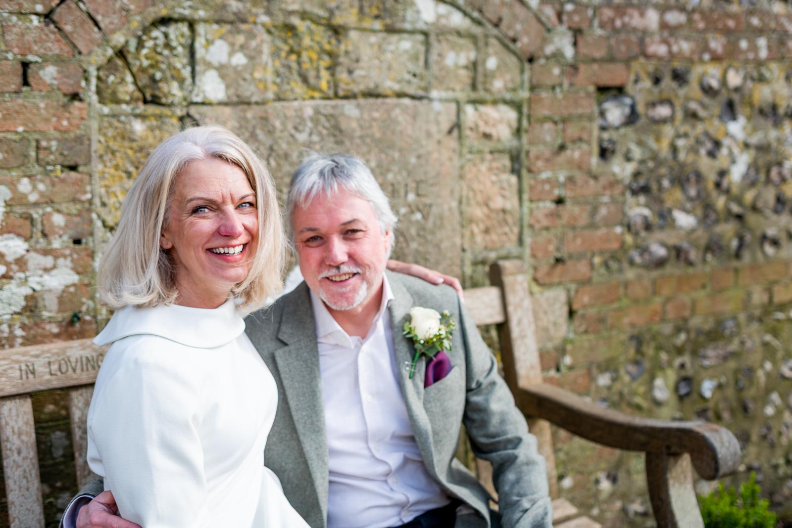 Jo and Darren sit at their favourite bench in Southover Grange, Lewes after their wedding