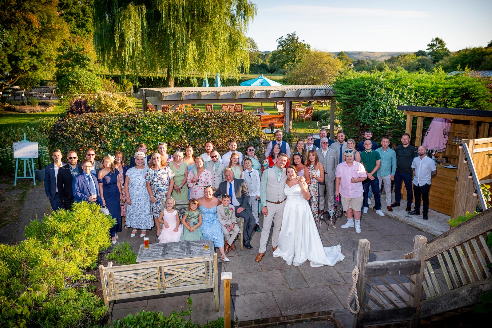 Tamsyn, Karl and their Wedding guests gather in the Garden at The Jolly Sportsman in Chiltington near Lewes with a view to the South Downs. 