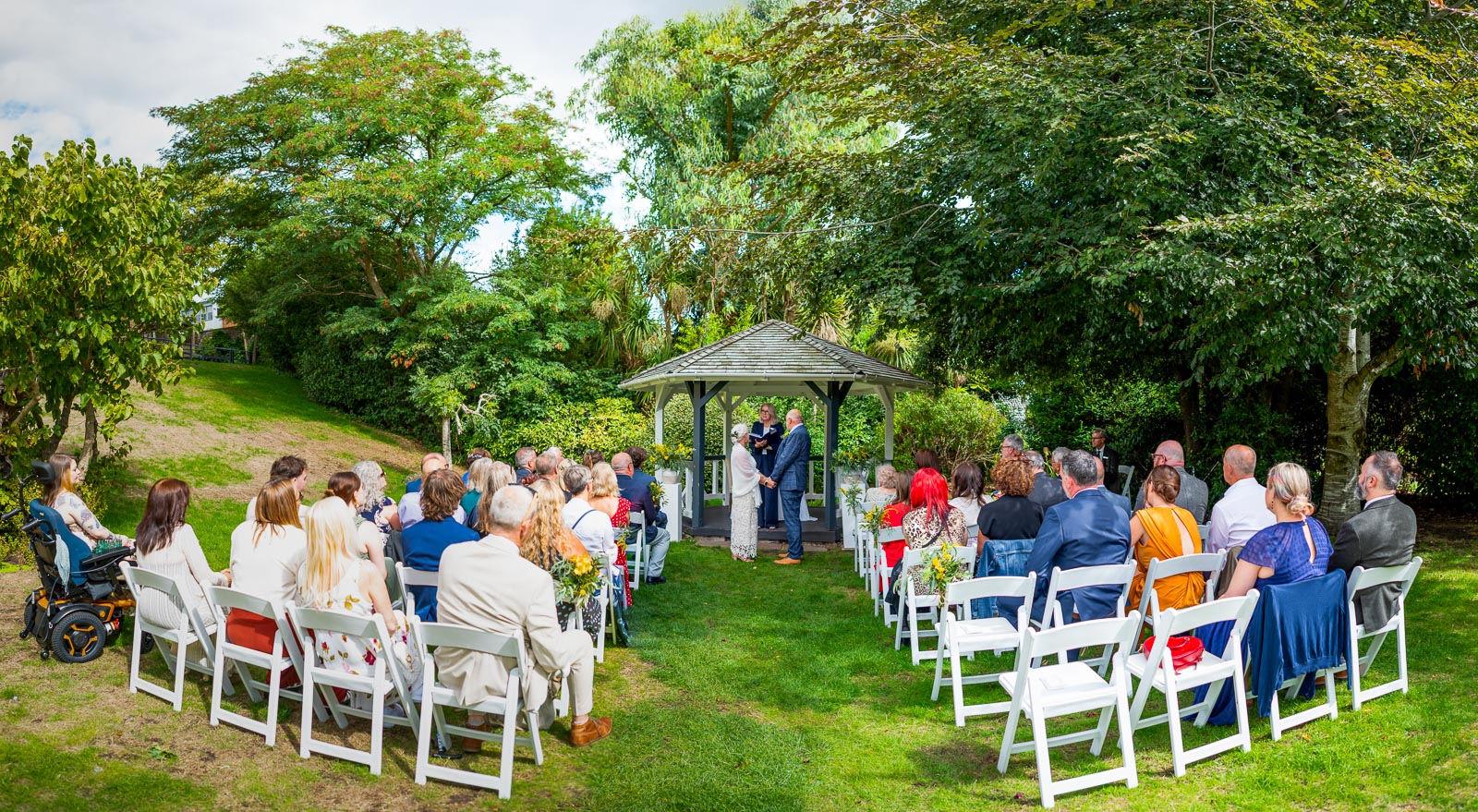 Karen and Hugh at the bottom of the aisle during their wedding in the Gardens at Pelham House Hotel, Lewes.