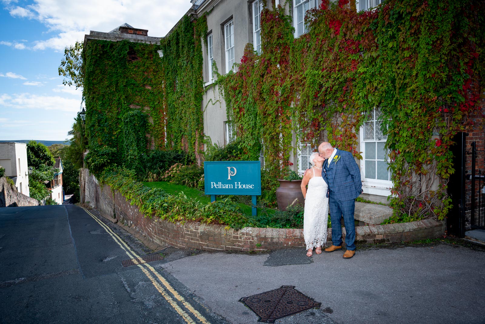Karen and Hugh kiss outside the front gates of Pelham House in Lewes following their wedding. 