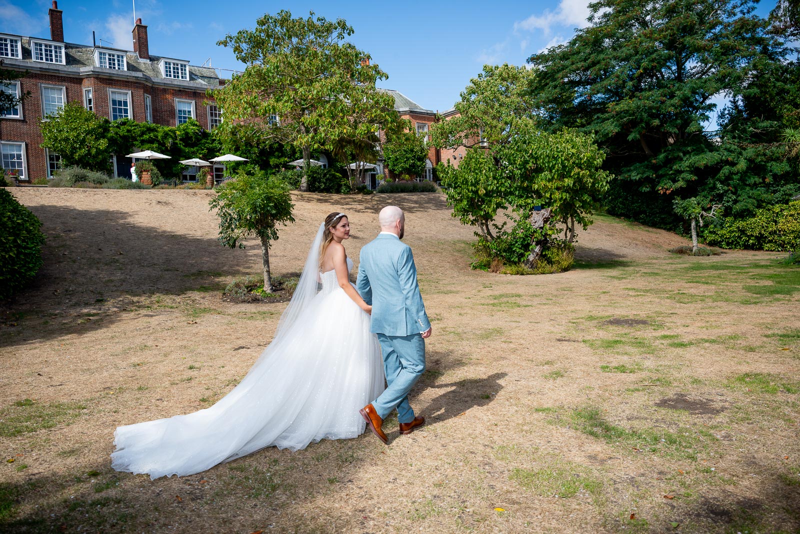 Sarah and Lewis walk through  the gardens at Pelham House Hotel, Lewes following their wedding.