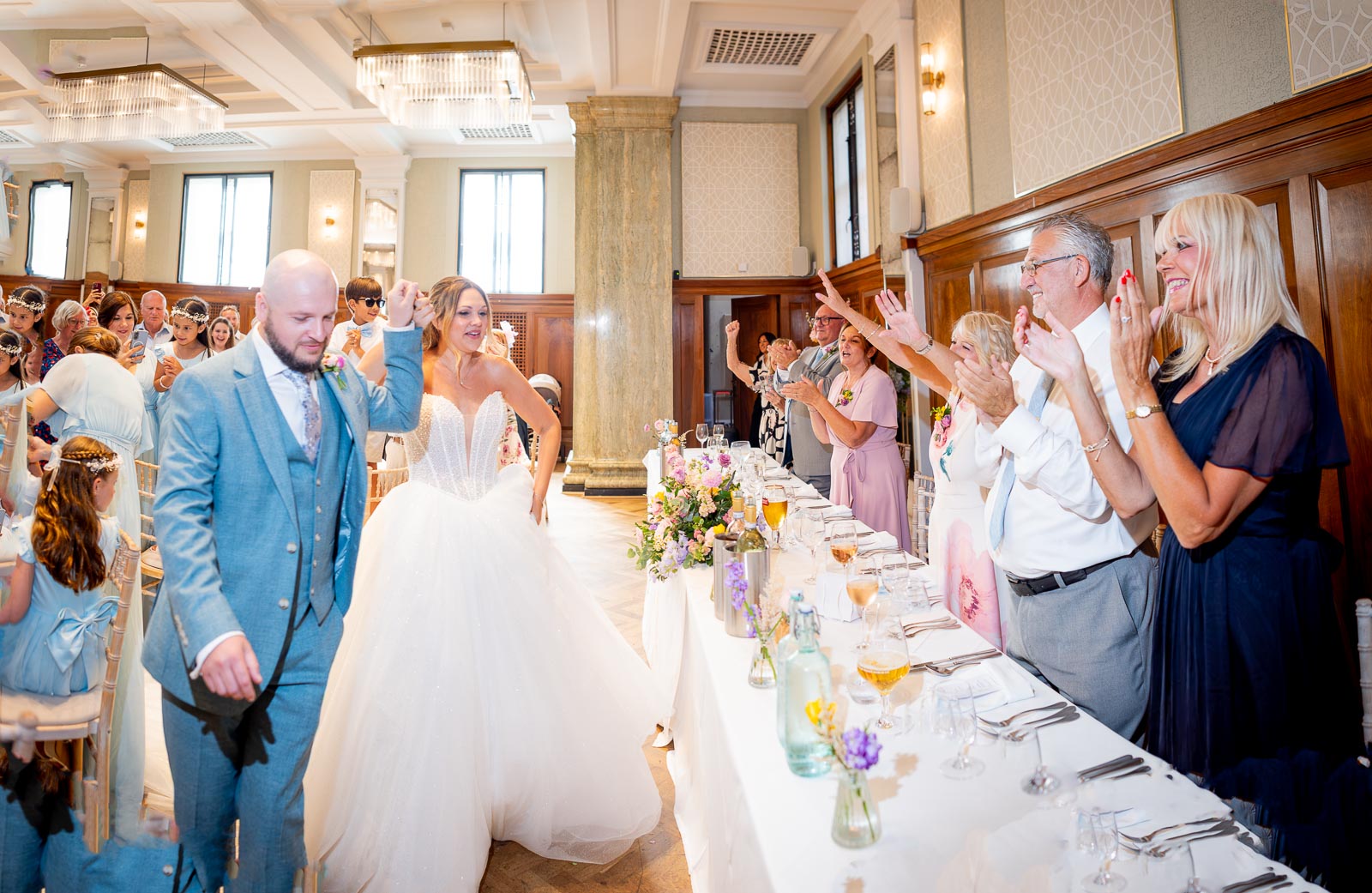 Sarah and Lewis walk to the top table  in the Blencowe Room at Pelham House Hotel, Lewes following their wedding.