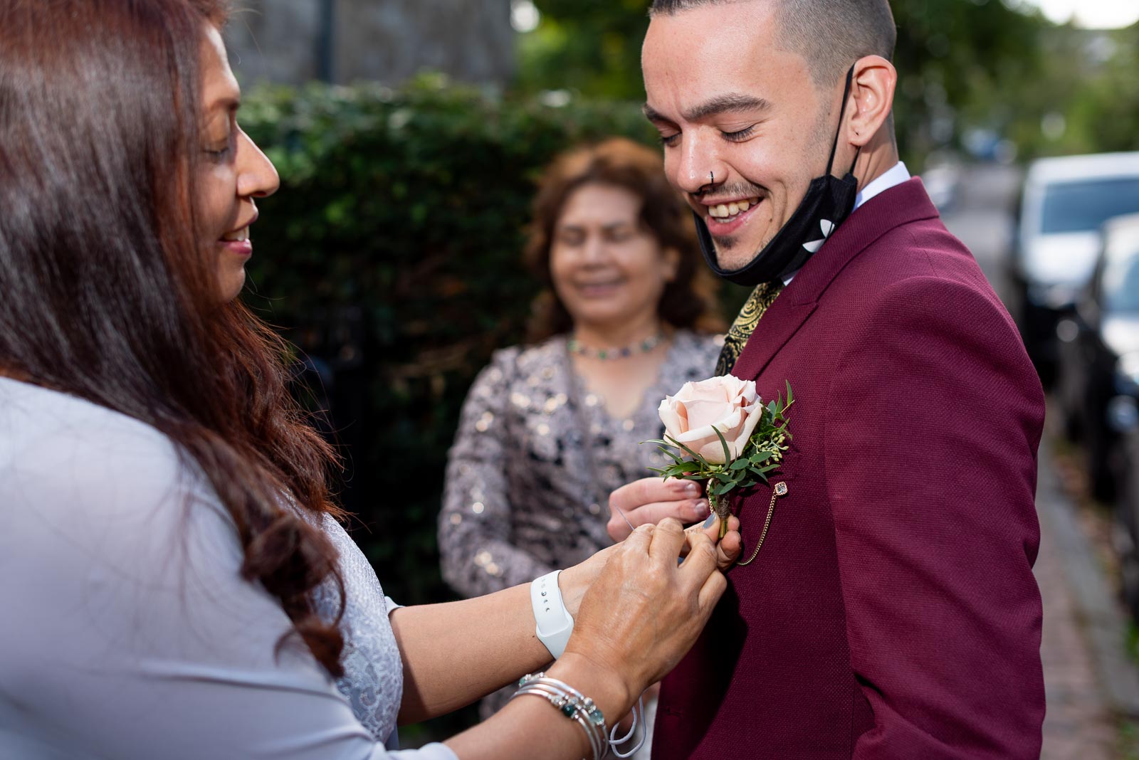 Ady's soon to be mother in law attaches a wedding pin to his lapel outside Lewes Registry Office.