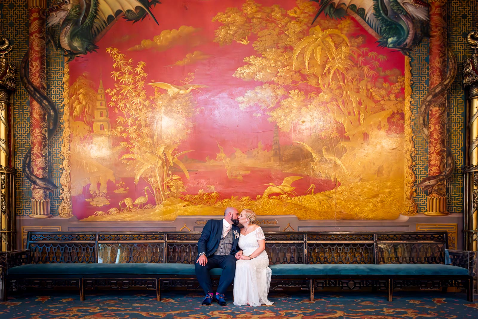 Georgina and Andy kiss on front of a huge painted fresco in The Music Room at Brighton Royal Pavilion.
