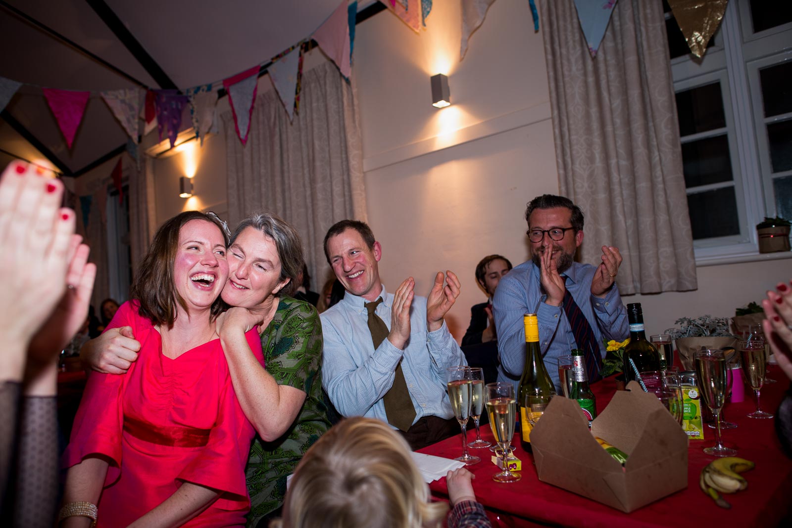Annie is hugged by wedding guests in Firle village Hall as Mark makes a speech.