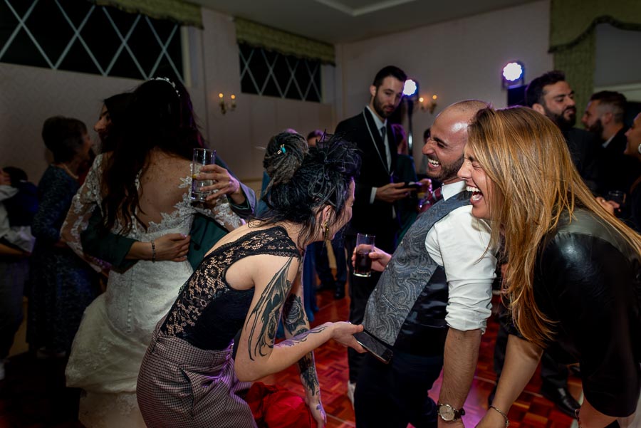 Wedding guests of Virginia and Simon enjoy a funny moment at their wedding reception in Horsted Place.
