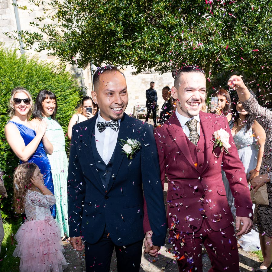 Ady and Jose walk through confetti thrown by their wedding guests in Southover Grange, Lewes.