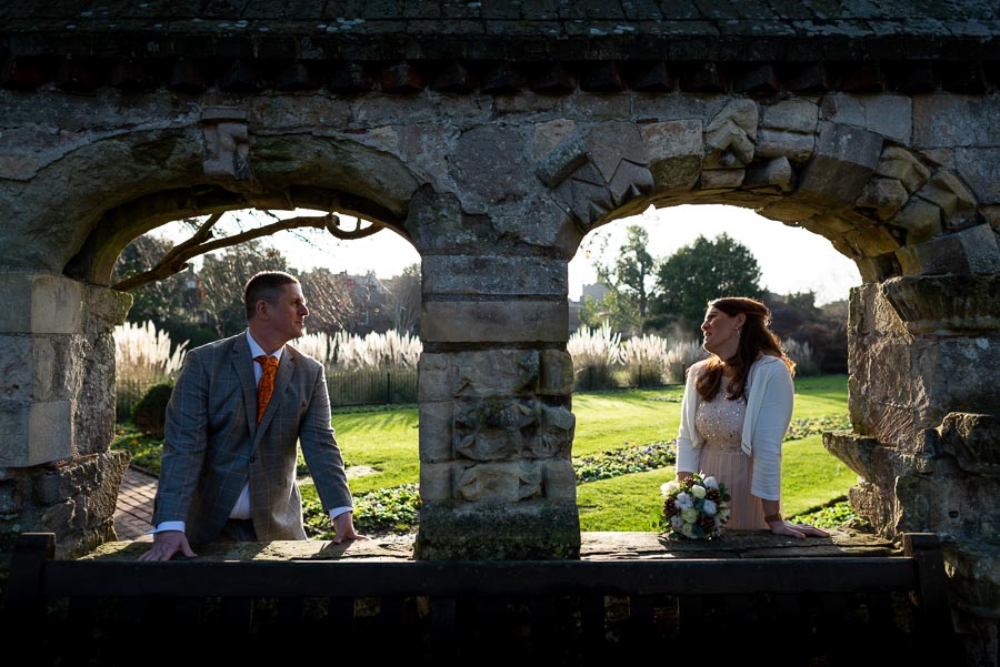 Grant and Jane look at eachother in the arches of Southover Grange after getting married at Lewes Register Office. 