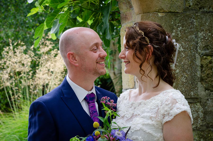 Katherine and Ben smile at eachother in Southover Grange, Lewes after their wedding.