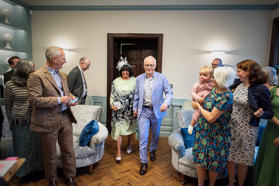 Ashifa and Julian enter the Evelyn Room at Lewes Register Office surrounded by family and friends before getting married.